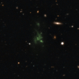 Lyman-alpha blob (LAB-1) pictured at the center is one of the largest known objects in the universe. Because of its distance, the blob’s UV emissions get stretched on their journey through space and appear green to our telescopes. Image: ESO/M. Hayes